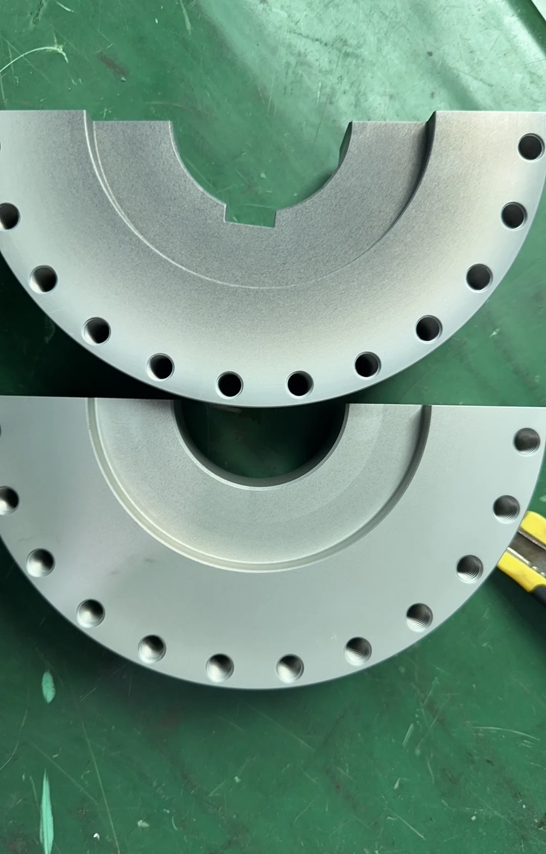 Two semicircular 6082 aluminum parts with visibly uneven surface color after anodizing