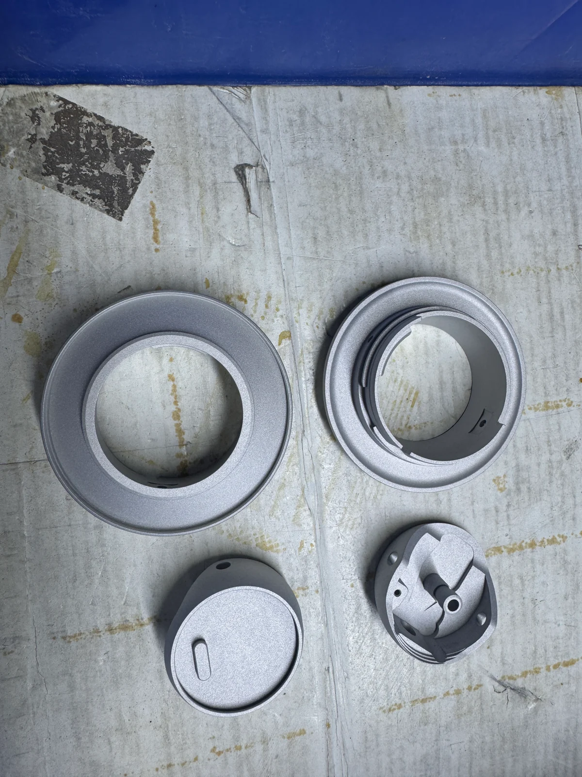 Four aluminum components with matte surfaces after blasting
