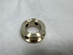 Finished high-strength brass robot joint bushing with black graphite lubrication inserts machined flush with the bearing surfaces